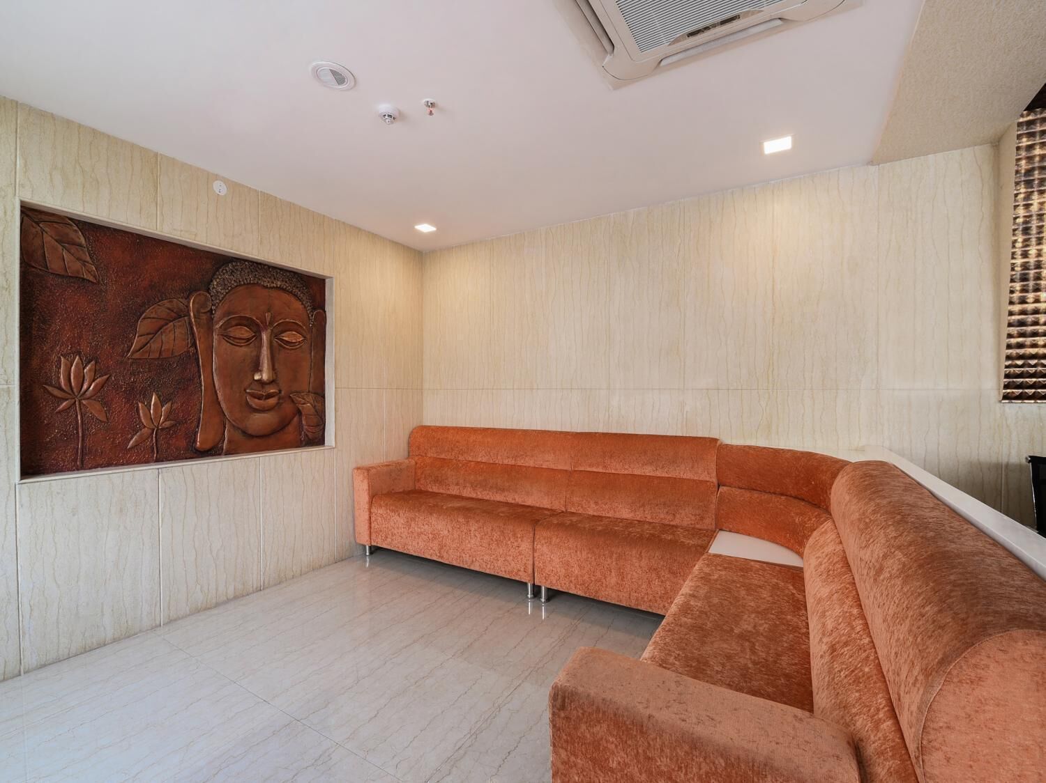 A modern interior with a large wall mural, a plush orange sofa, and a tiled floor.