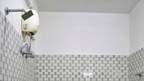 Et badeværelse med toilet, bruser og bidet.