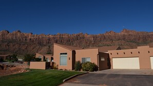 A residential area with modern houses, a clear blue sky, and a mountain range in the background. - Mountain Views In the heart Of Canyon Country; Adventure base for your visit! (Moab)