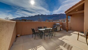 A patio with a table and chairs, a grill, and a view of mountains. - Mountain Views In the heart Of Canyon Country; Adventure base for your visit! (Moab)