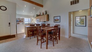 A spacious kitchen with wooden cabinets, a dining area with a wooden table and chairs, and a clock on the wall. - Mountain Views In the heart Of Canyon Country; Adventure base for your visit! (Moab)