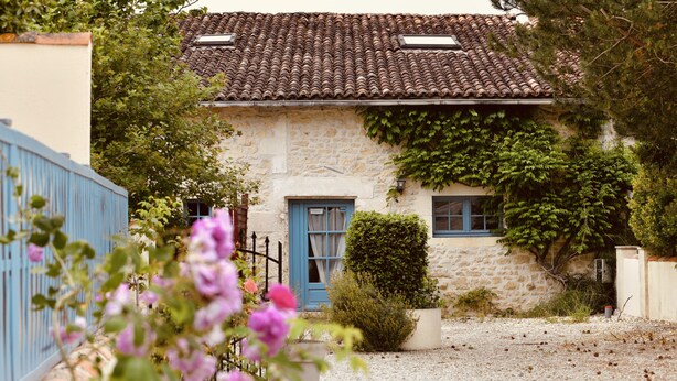 A stone house with a tiled roof, a blue door, and a gravel driveway. - Domaine Les Granges (Ternant)
