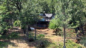 A lakeside property with a house surrounded by trees, a dock, and a fenced area. - Top Lakefront Oasis - Kayaks, Paddle Bd, - Shasta Lakeshore Retreat #2 (Lakehead)