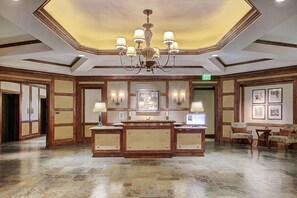 A lobby with a central reception desk, framed artwork on the walls, and a chandelier. - Valley View Condo | Pool & Whirlpool on site! (Vail)