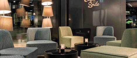 A modern lounge area with multiple seating options, including sofas and armchairs, arranged around a central coffee table.