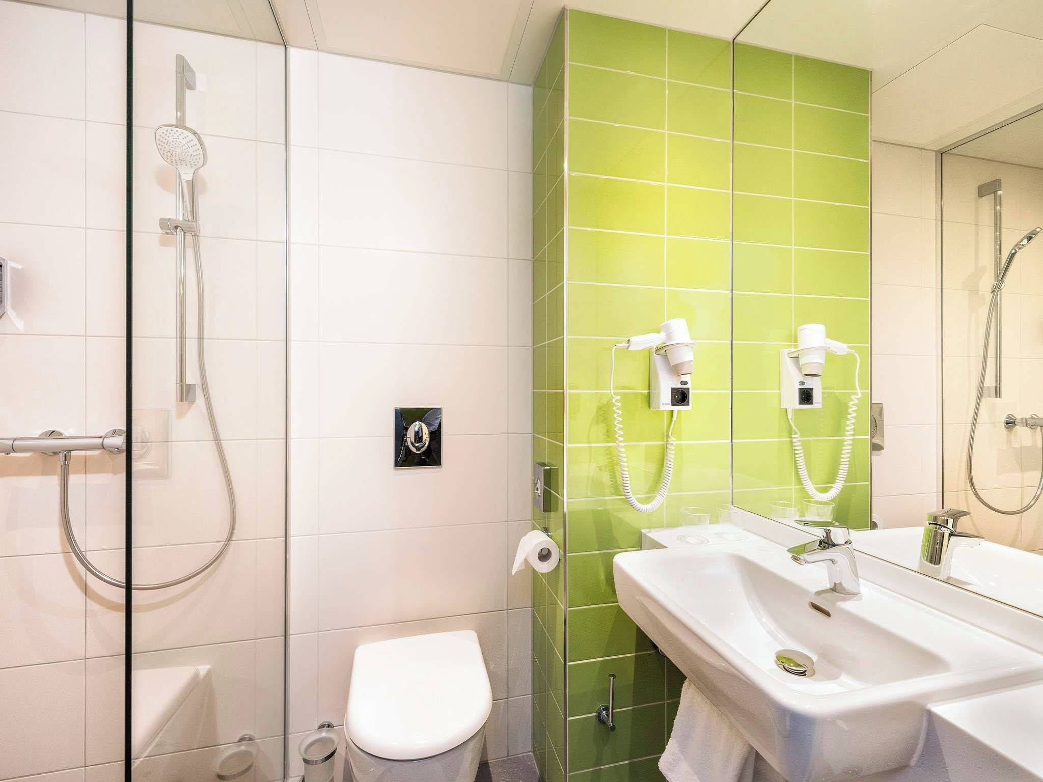 Un baño con ducha, inodoro y lavabo.