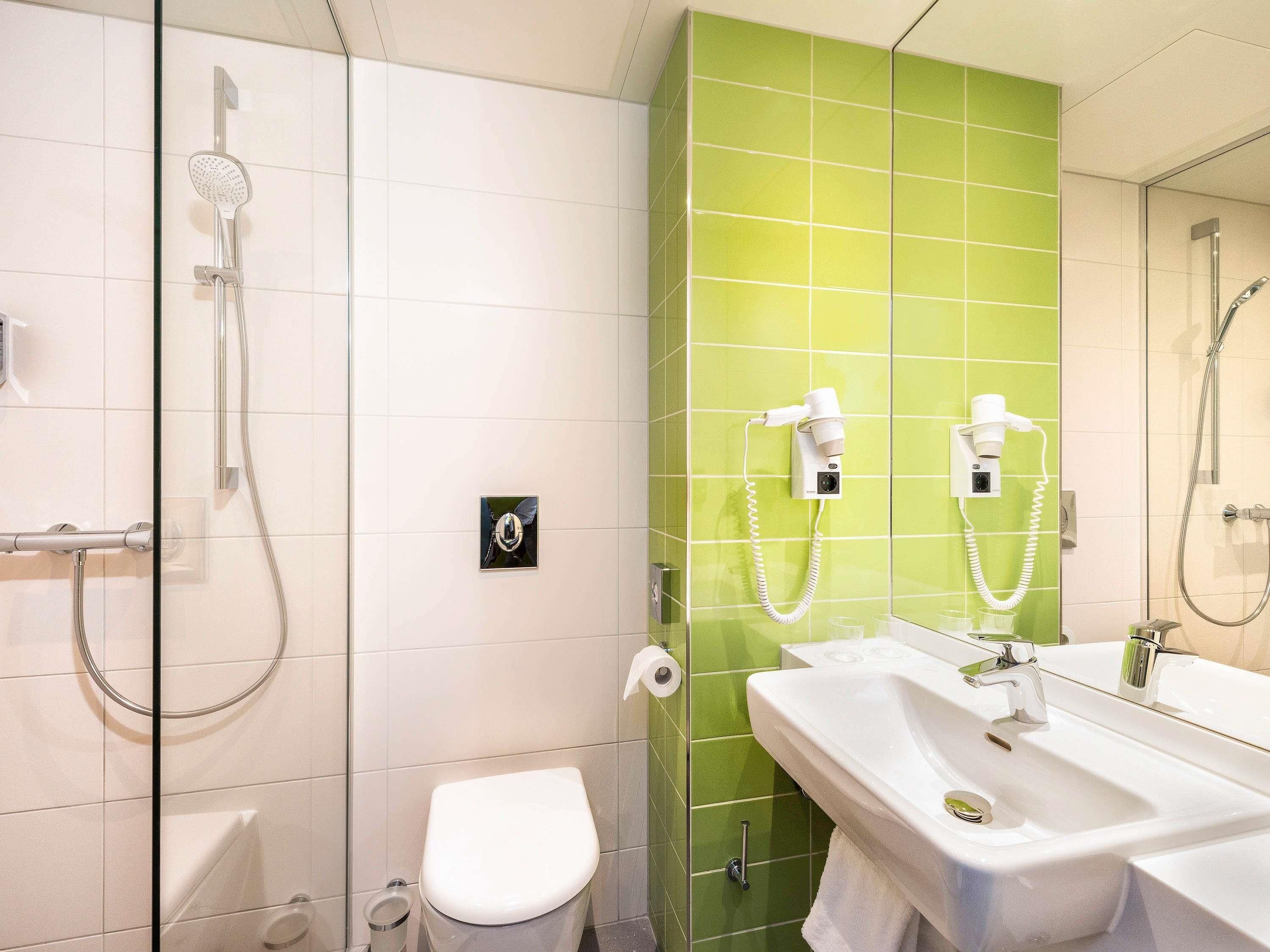 Ein Badezimmer mit Dusche, Toilette und Waschbecken.