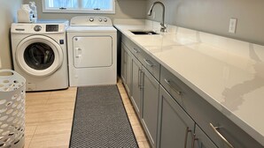 Ett tvättrum med tvättmaskin, torktumlare och tvättho.