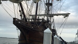 Un barco grande amarrado en el muelle, con mástiles y aparejos a la vista.