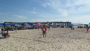 Una playa con sombrillas y gente.