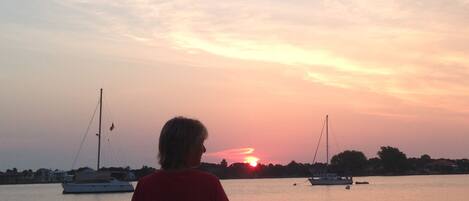 Un tramonto su un'acqua calma con barche.