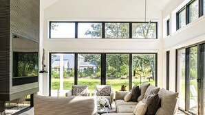 A modern living room with a large sectional sofa, a coffee table, and a flat-screen TV mounted on the wall. - Modern 6Bed-6Bath New in 2023! (Edgartown)