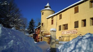 Ein schneebedecktes Gebäude mit einem Schild, auf dem 'LE CHATEAU' steht.