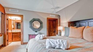 A bedroom with a bed, a mirror, a wooden door, a nightstand, and a lamp. - Awesome Ski Experience in Large Condo (Cordillera)