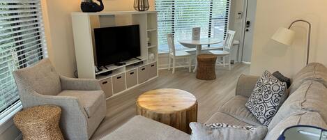 A modern living room with a TV, sofa, and dining area.