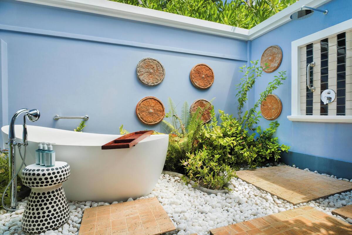 A bathroom with a freestanding bathtub, a towel rack, and decorative wall art.
