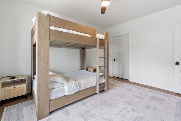 A bunk bed with a ladder, a bedside table, and a nightstand. - Downtown Sister Bay Waterfront Condo – Walk to Everything (Sister Bay)