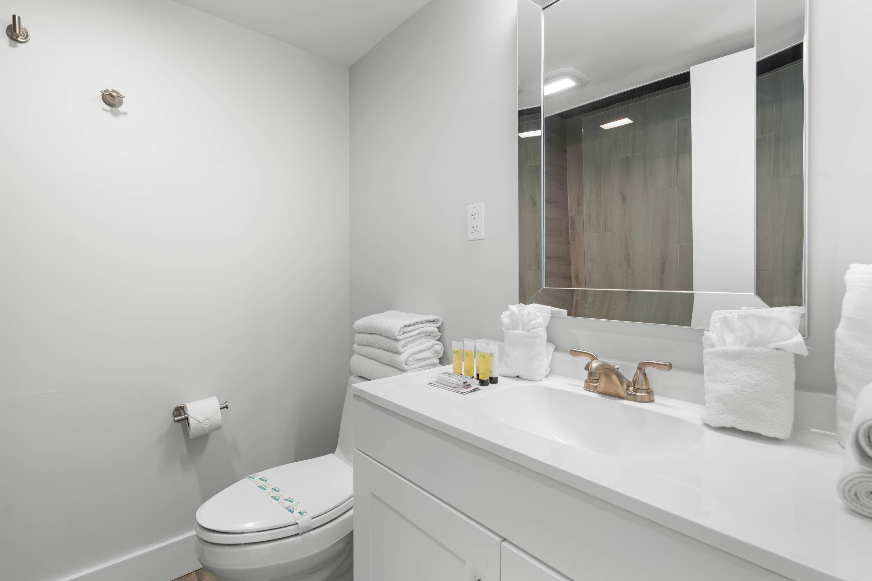 Un bagno moderno con WC, lavandino e specchio.