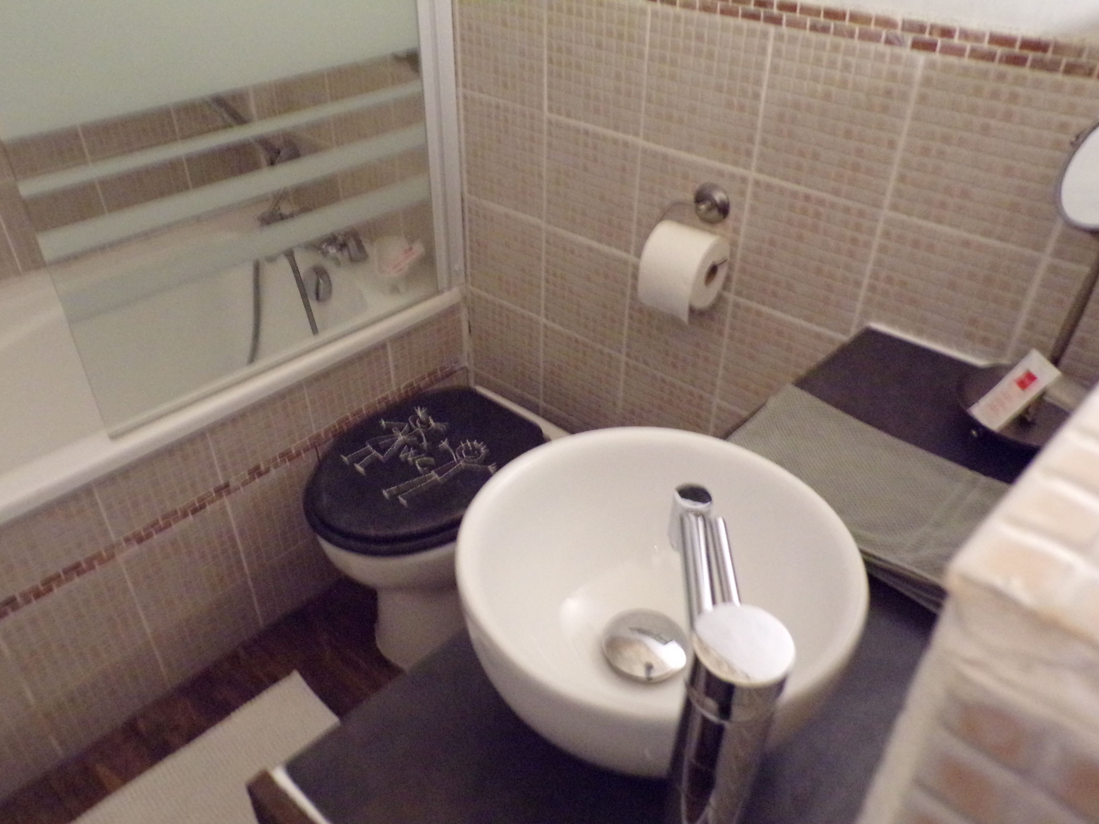 Un baño con inodoro, lavamanos y zona de ducha.