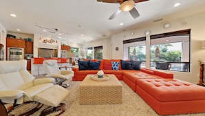 A modern living room with a sectional sofa, a rocking chair, and a coffee table. - Experience luxury at Paramount, featuring stunning mountain views, a large pool and game room! (Indio)