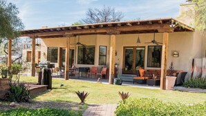 A covered outdoor patio with seating, a grill, and a pathway leading to the entrance. - Rancho Privado Tucson AZ (Tucson)