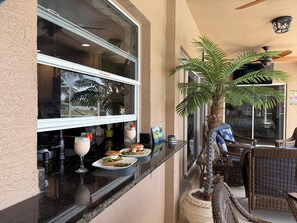 Ein Restaurant mit Außenbereich, einem großen Fenster und einer Palme.