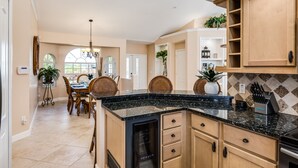 Una cocina con encimera de granito negro, armarios de madera y lavavajillas integrado.