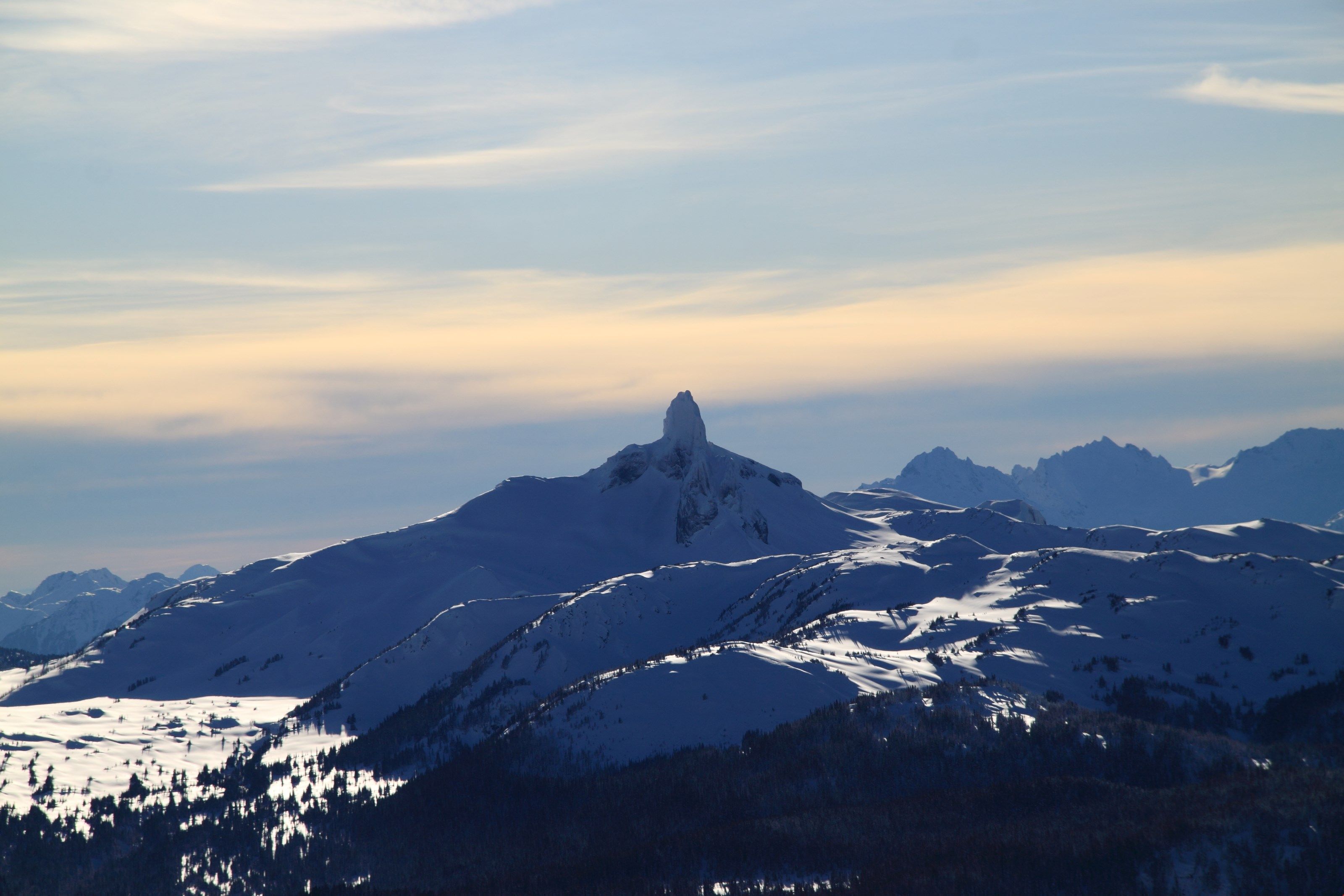 A snow-covered mountain range with a prominent peak.