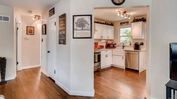 A modern kitchen with white cabinets, a microwave, and a clock on the wall. - NEW! Walk to Old Littleton and light rail from this lovely home w/private yard (Littleton)