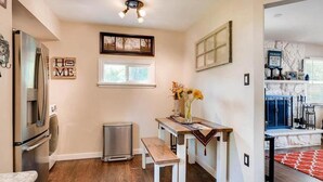 A compact kitchen with a refrigerator, a sink, and a small dining table with a bench. - NEW! Walk to Old Littleton and light rail from this lovely home w/private yard (Littleton)