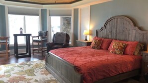 A bedroom with a wooden bed, a desk, and a chair. - Private, Romantic, Lake Norman Waterfront Suite, Hot Tub + Dock + Sunset Views (Mooresville)