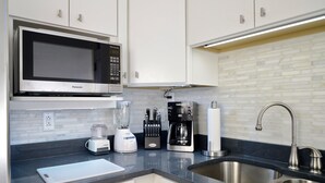 A modern kitchen with white cabinets, a stainless steel sink, a microwave, a coffee maker, and a blender. - Beautiful 2BR Apt. /Pittsburgh/East/Regent Square/Frick Park (Pittsburgh)