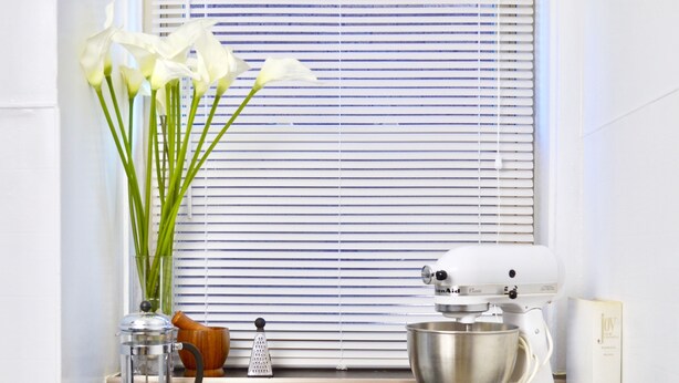 A kitchen counter with a stand mixer, a bowl, a cutting board, and a vase with flowers. - Beautiful 2BR Apt. /Pittsburgh/East/Regent Square/Frick Park (Pittsburgh)