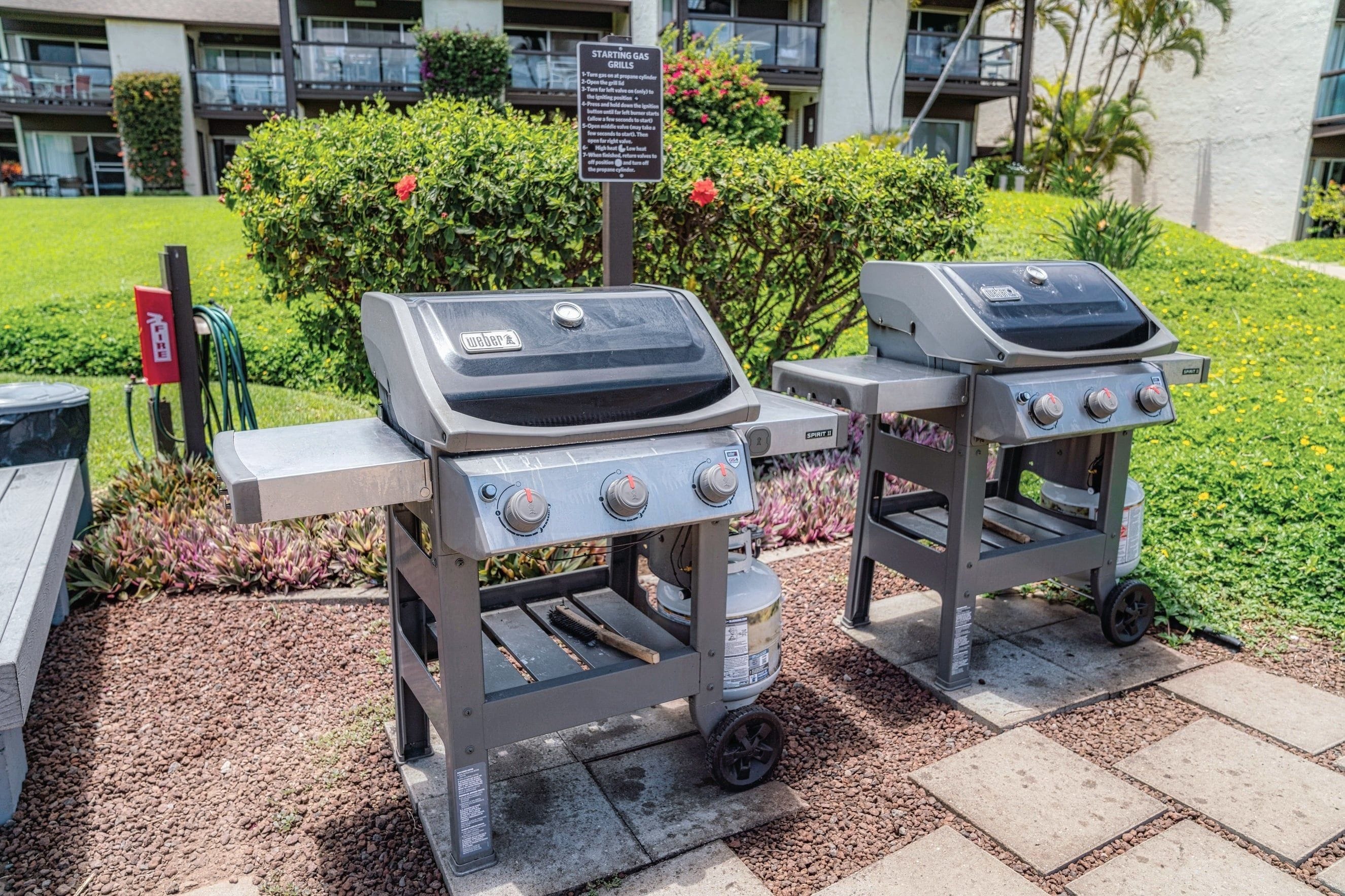 Two portable gas grills with controls, a gas canister, and a starting gas grill sign.