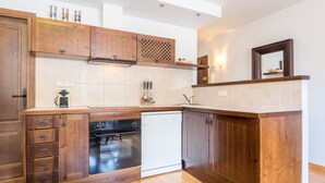 Eine moderne Küche mit Holzschränken, einem Geschirrspüler und einem eingebauten Backofen.