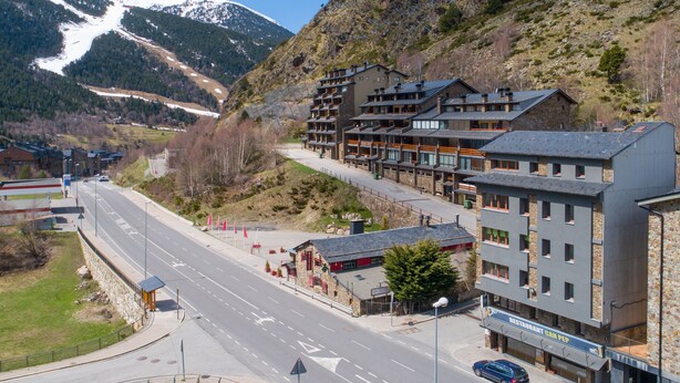 Un hotel moderno con varios pisos, un restaurante y vistas a una montaña.