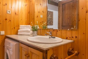 A wooden-paneled bathroom with a sink, a mirror, and a washing machine. - La Pleta Del Tarter Apartments (El Tarter)