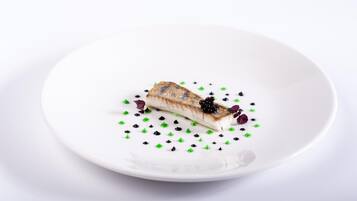 Une assiette blanche avec un morceau de nourriture et des éléments décoratifs.