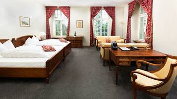 Une chambre d’hôtel avec un grand lit, un bureau, une chaise et un canapé.