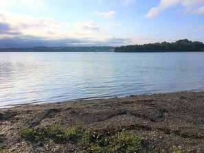 Escape to a serene lakeside haven with a pebbly shore and tranquil waters.