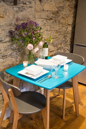 Enjoy a romantic meal for two at this cozy dining area, complete with a table, chairs, and a vase of fresh flowers.