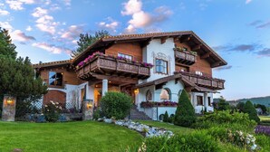 A traditional chalet with wooden balconies, a stone fence, and a well-maintained garden. - Abendblume - Adults Only (Leavenworth)