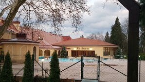 Un centro de bienestar con piscina, zona vallada y edificio de techo rojo.
