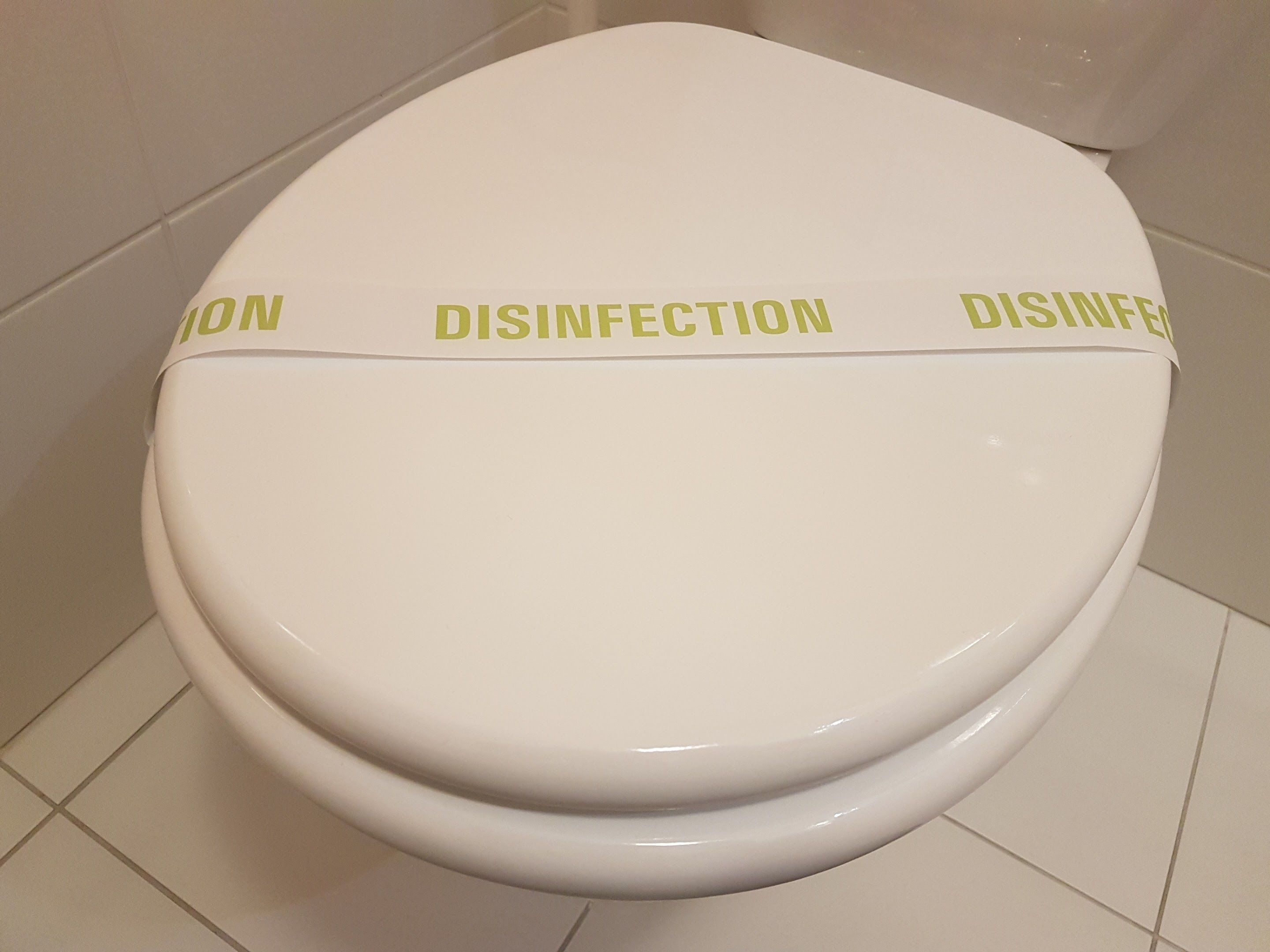 Un inodoro con tapa etiquetada como 'DISINFECCIÓN'.