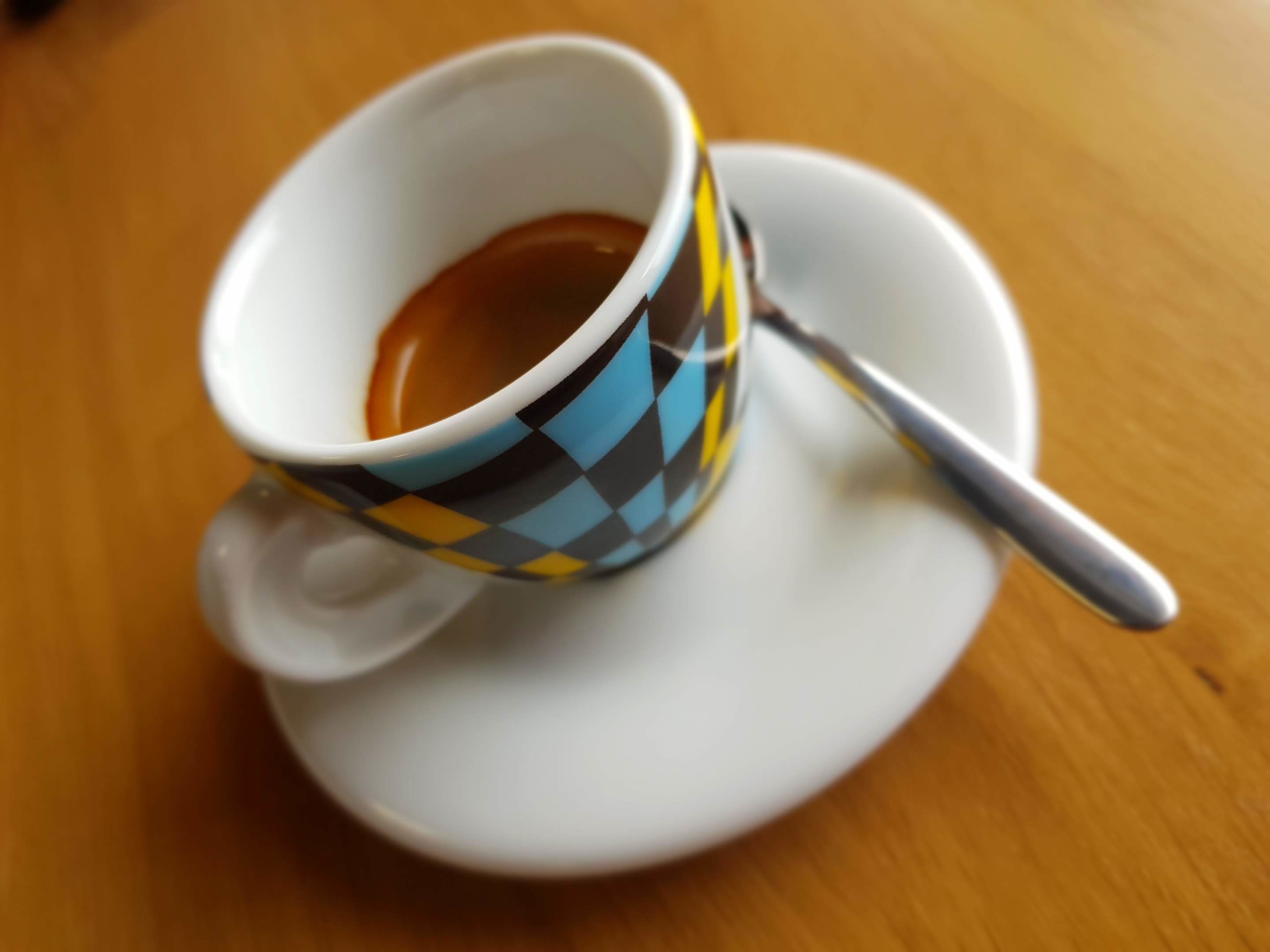 Una taza de café sobre un plato con una cuchara.