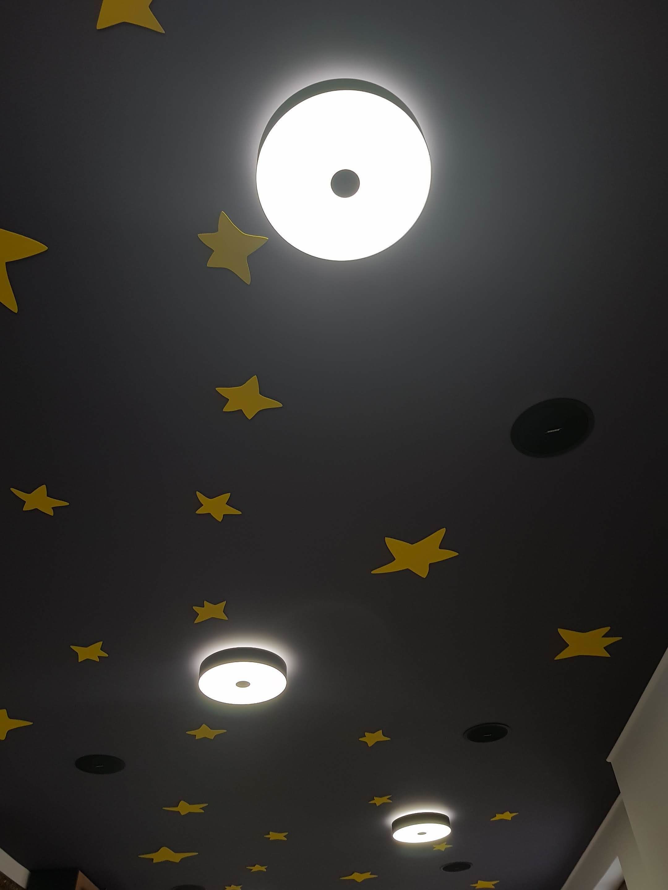 A ceiling with star-shaped decorations and recessed lighting.