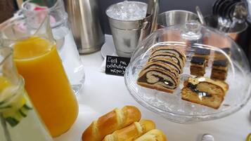 A breakfast setting with pastries, a glass of orange juice, and a coffee pot.