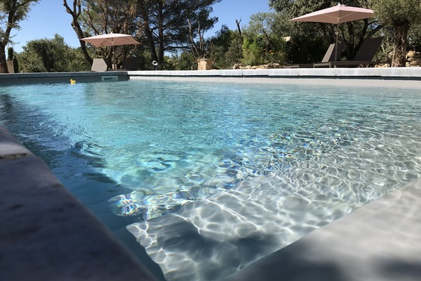 Een seizoensgebonden buitenzwembad en parasols bij het zwembad