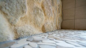 Primer plano de un muro de piedra y suelo de baldosas.
