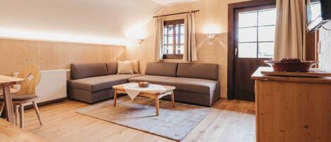A cozy living room with a sofa, a coffee table, and a dining area with a table and chairs.